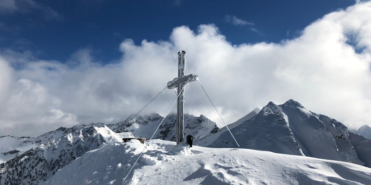 Das tief verschneite Gipfelkreuz am Krahbergzinken | © Florian Zimmermann