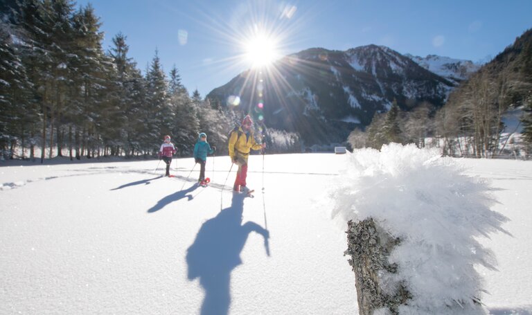 Begleitet von der strahlenden Sonne warten 3 Personen durch den Schnee | © Gerhard Pilz