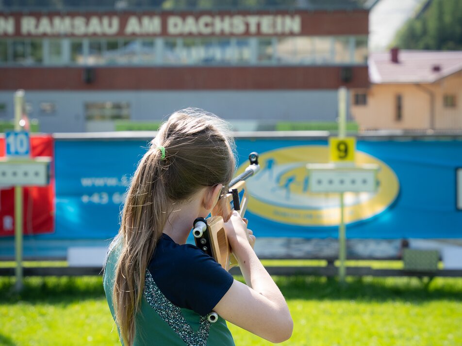 Ein Mädchen zielt mit einem Lasergewehr beim Kinder-Laserbiathlon in Ramsau am Dachstein. | © TVB/Laura Passenbrunner
