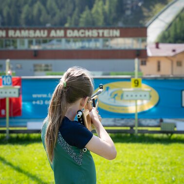 Ein Mädchen zielt mit einem Lasergewehr beim Kinder-Laserbiathlon in Ramsau am Dachstein. | © TVB/Laura Passenbrunner