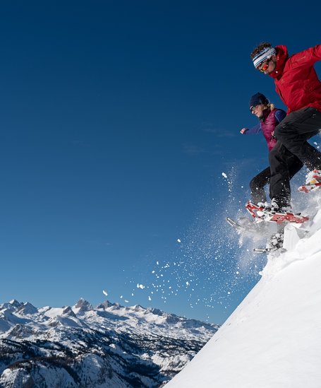 Snowshoe hikers jumping into the powder in Schladming-Dachstein | © Herbert Raffalt