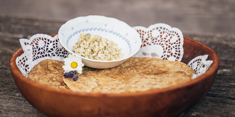 Auf auf einem Holztisch steht eine Schüssel mit frischen Steierkrapfen | © Schladming-Dachstein_Gerald Grünwald