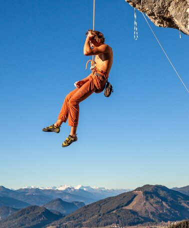 Kletterer hängt am Seil in der Felswand | © René Eduard Perhab