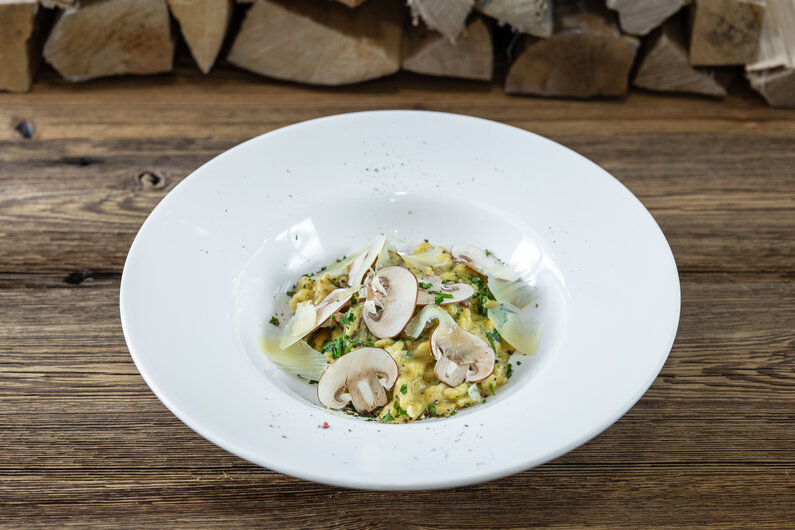 Nockerl Champignon mit Speck und Käse in einem Teller serviert | © Martin Huber