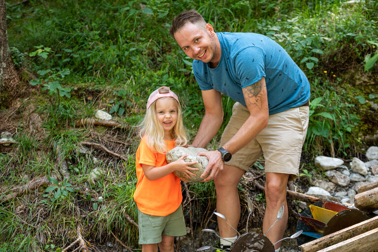 Vater hält gemeinsam mit Tochter großen Stein in der Hand  | © Lorenz Maser 