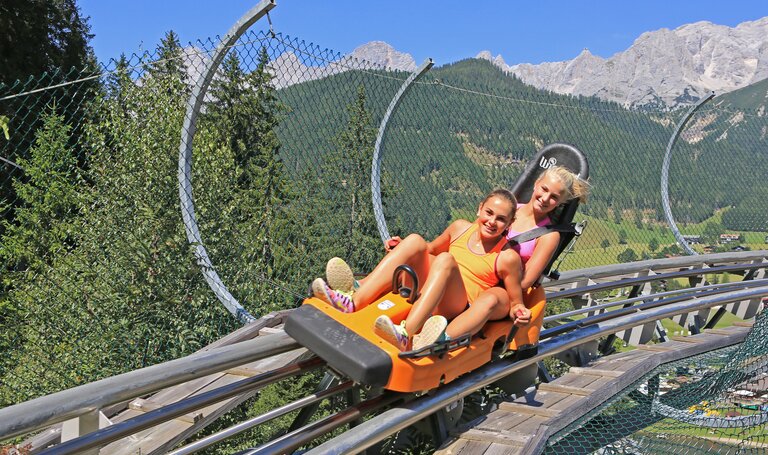 Teenagers in the summer toboggan run Alpin Coaster