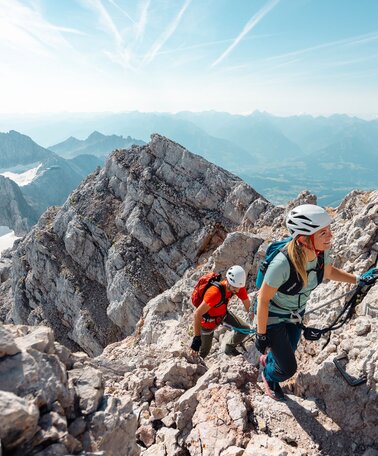 Eine Frau und ein Mann in Kletterausrüstung am Weg zum Dachsteingipfel | © Mathäus Gartner
