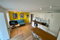 Wohnküche mit klappbarer Couch und Flatscreen-TV