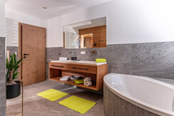 Großzügiges Badzimmer mit Badewanne und Dusche