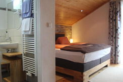 Doppelzimmer mit Boxspringbett und Balkon.