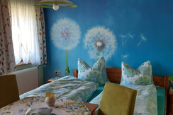 Doppelbett und Balkon - das Löwenzahnzimmer im Ferienhaus Tschernitz