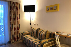 Blumen Studios_Hauser Kaibling_Couch und Kabel-TV